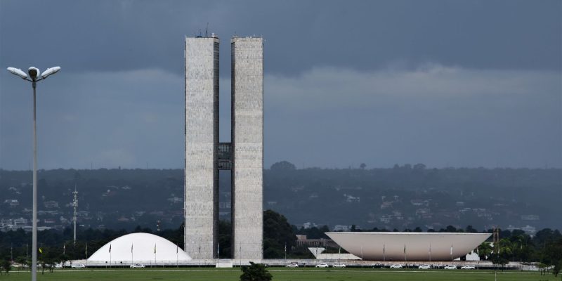 Vista do Congresso Nacional em Brasília, com suas cúpulas e torres sobre a arquitetura modernista.