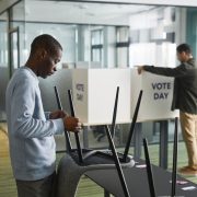 Homens organizam cabines de votação em uma seção eleitoral interna.