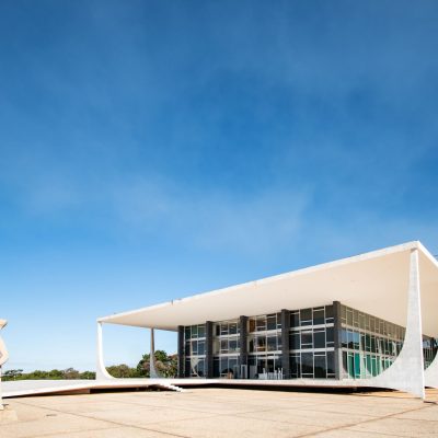 Vista externa da arquitetura modernista do Supremo Tribunal Federal, em Brasília, sob céu azul.