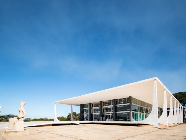Vista externa da arquitetura modernista do Supremo Tribunal Federal, em Brasília, sob céu azul.
